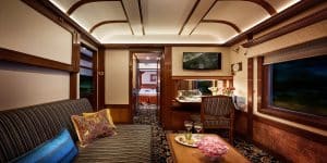 Salon de la Suite Pr&eacute;sidentielle du train Deccan Odyssey avec canap&eacute; ray&eacute;, table basse et d&eacute;cor raffin&eacute;